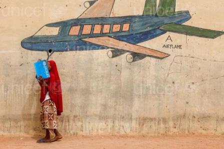 Le 17 Mars, Alia, 10, couvre son visage avec un dossier tout en se tenant devant une fresque murale d'un avion, dans un camp pour personnes déplacées à l'intérieur, à Yola, capitale de l'Adamaoua, un état dans le nord-est du Nigéria.